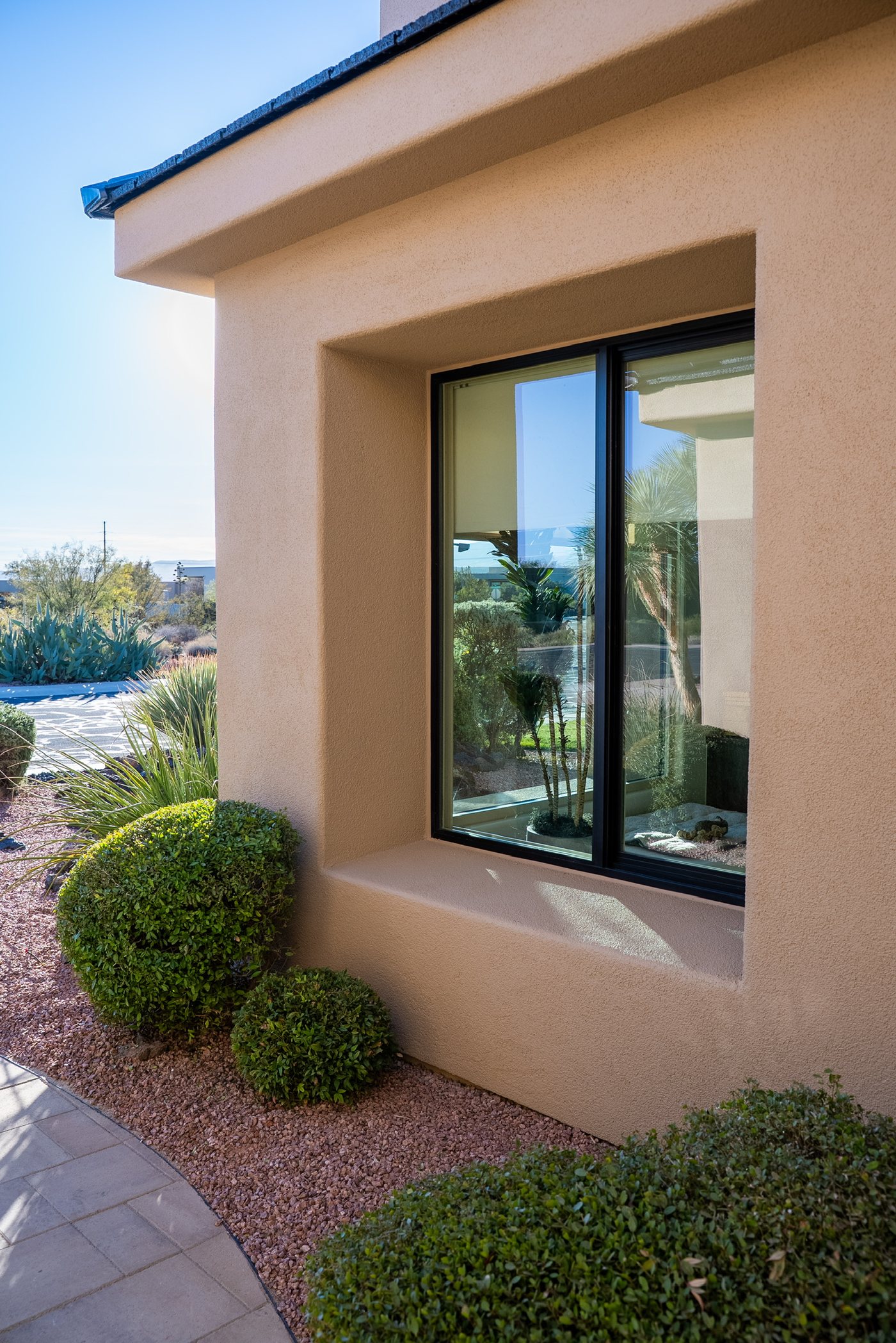 Black-framed JKR window installed on a stucco home
